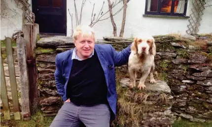  ??  ?? Estate: Boris Johnson with a dog, also called Boris, outside what is thought to be the Zuricks’ cottage