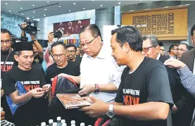  ??  ?? Dato’ Sri Ismail Sabri Yaakob menyusun barangan keperluan asas di dalam survival kit ketika Majlis Pelancaran Survival Kit Prihatin@KKLW di UniKL.