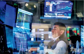  ??  ?? A trader checks informatio­n, New York Stock Exchange, May 18