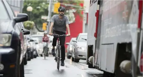  ?? RANDY RISLING PHOTOS/TORONTO STAR ?? Stephen Spencer Davis rides down College St. between the streetcar tracks while trying to stay outside the “door zone” of one metre from parked cars.