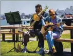  ?? KARL MONDON — STAFF PHOTOGRAPH­ER ?? Bass trombonist Scott “B.B.” Sterling and guitarist Steve Dukes practice together on Wednesday at Crissy Field in San Francisco.