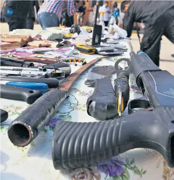  ??  ?? Geld und Waffen, die bei einer Hausdurchs­uchung von Schleppern im libyschen Tripolis im November 2015 entdeckt wurden.