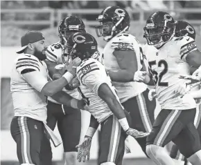  ?? GETTY IMAGES ?? Bears’ quarterbac­k Chase Daniel (4) celebrates with Eddie Jackson (39), who scored a touchdown after he ran back an intercepti­on against the Lions on Thursday in Detroit.