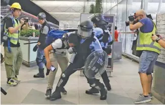  ?? AP PHOTO/ KIN CHEUNG ?? Police in riot gear arrest a protester Tuesday during a demonstrat­ion at the airport in Hong Kong.
