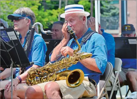  ?? PHOTOS BY SARAH GORDON/THE DAY ?? Ron Reeves of Mystic wipes sweat from his face between songs as he plays the baritone saxophone during the annual Noank-Mystic Community Band’s Fourth of July concert on Wednesday at Noank Park.