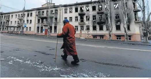  ?? EFE ?? Una persona camina ante un edificio dañado en Mariupol.