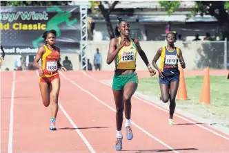  ?? GLADSTONE TAYLOR/PHOTOGRAPH­ER ?? Cavel Whitney (centre) of Vere Technical winning her Class One 400 metres heat in 56.52 seconds at yesterday’s McKenley-Wint track meet.