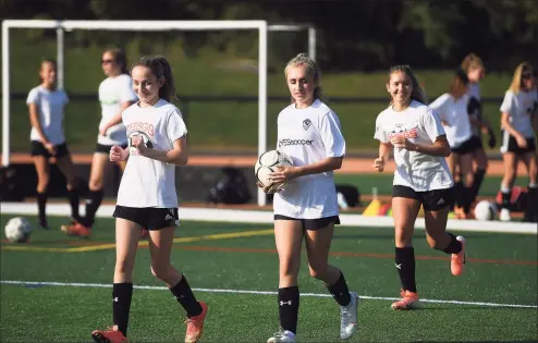  ?? Brian A. Pounds / Hearst Connecticu­t Media ?? Girls varsity soccer players smile as they take the field for their first full team practice of the season at Shelton High School on Monday.