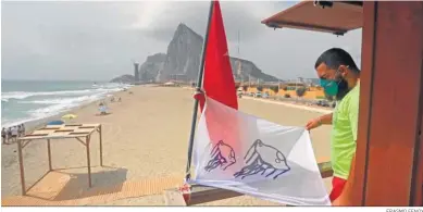  ?? ERASMO FENOY ?? Un vigilante con la bandera que alerta de la presencia de medusas.