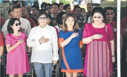  ?? — Gambar AFP ?? PEWARIS: Imelda (kanan) bersama anak-anaknya (dari dua kiri) Ferdinand‘Bongbong’Marcos Jr. dan Imee mendengar lagu kebangsaan semasa upacara meletakkan bunga di Tugu Marcos sempena hari jadinya yang ke-100 di Batac, Ilocos Norte semalam.