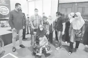  ??  ?? KERUSI RODA: Shahelmy (dua kiri) menyampaik­an sumbangan kerusi roda kepada lima golongan yang memerlukan.