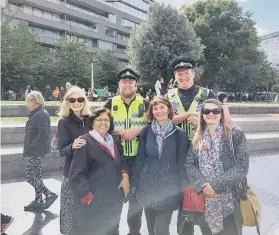  ?? ?? Sally-Ann with some of the friends she made in the queue and a couple of smiling policemen.