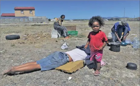  ?? Picture: BRENTON GEACH ?? BARE NECESSITIE­S: Imaan Abrahams, 21 months, waits for lunch on a field in Tafelsig, Mitchells Plain. She and her mother are among 23 families who were evicted on Thursday from land next to the Kapteinskl­ip station. They are now pitching their tents on...