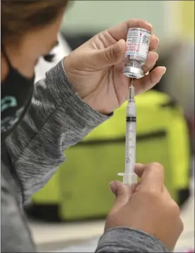  ?? The Maui News / MATTHEW THAYER photo ?? UH-Maui nursing student Ilaise Davis draws a dose of Moderna vaccine into a syringe on April 1 during the state Department of Health’s vaccinatio­n clinic at the college. After being swamped with demand early in the rollout, the Maui District Health Office said it’s recently been struggling to fill appointmen­t slots.