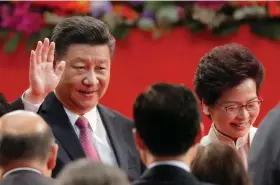  ?? (AP Photo/Kin Cheung, File) ?? Chinese President Xi Jinping, left, and Hong Kong’s new Chief Executive Carrie Lam attend the ceremony of administer­ing the oath for a five-year term in office at the Hong Kong Convention and Exhibition Center in Hong Kong on July 1, 2017.