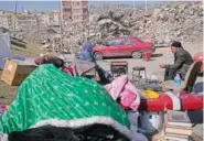  ?? AP PHOTO/HUSSEIN MALLA ?? A Turkish man and his wife rest Wednesday after collecting belongings from their destroyed house in Kahramanma­ras city, southern Turkey.