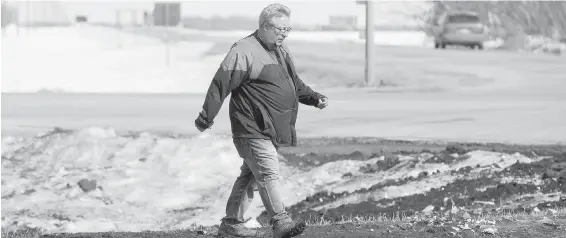  ??  ?? Myles Shumlanski surveys the intersecti­on of Friday’s fatal bus crash. He was one of the first to arrive at the collision scene, after his son walked out of the wreck and phoned.