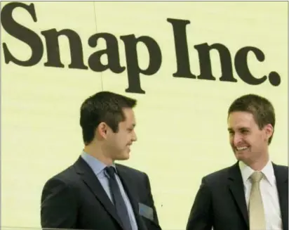  ?? RICHARD DREW — THE ASSOCIATED PRESS FILE ?? Snap co-founders Bobby Murphy, left, and CEO Evan Spiegel ring the opening bell at the New York Stock Exchange as the company celebrates its IPO. Snap Inc. reports earnings, Thursday.