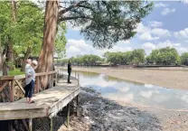  ?? Billy Calzada / Staff photograph­er ?? A puddle remains in Lake Dunlap in May after a dam failure drained the lake. The water level now is down 12 to 14 feet.