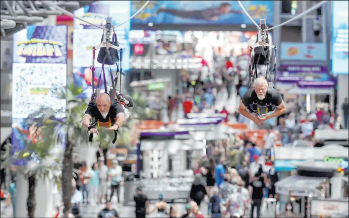  ?? Las Vegas Review-journal @Kmcannonph­oto ?? K.M. Cannon
Billy Hill of Henderson, left, and Tony Cox of Las Vegas ride the zip line during a Slotzilla hiring event Thursday at the Fremont Street Experience in downtown Las Vegas.