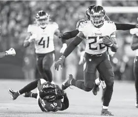  ?? Julio Cortez, The Associated Press ?? Titans running back Derrick Henry runs past Ravens strong safety Chuck Clark during Tennessee’s 28- 12 victory over Baltimore in the Jan. 11 NFL divisional playoff game in Baltimore.