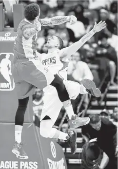  ?? Karen Warren / Houston Chronicle ?? Michael Beasley, left, and Austin River stage a midair ballet of sorts.