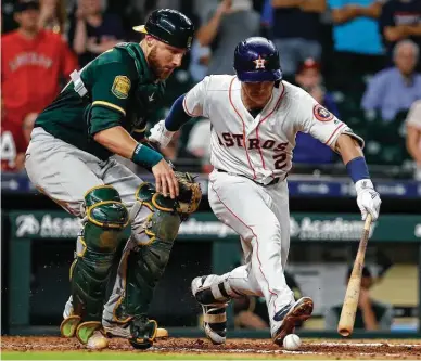  ?? Karen Warren / Houston Chronicle ?? After homering twice, Alex Bregman wins Tuesday’s game by hitting the ball a few feet, setting in motion a play on which A’s catcher Jonathan Lucroy missed the tag on Bregman and then hit him with the throw as the winning run scored.