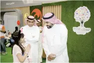  ??  ?? الوزير عبداهلل السواحة يستمع لطفلة زائرة لفعاليات المهرجان. (عكاظ)