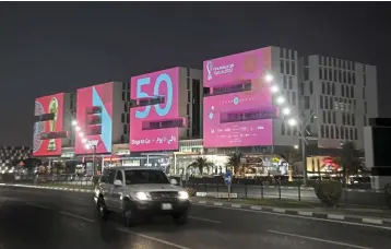  ?? ?? Football showcase: A general view shows the 2022-shaped building near Doha Sports City. Workers are pouring concrete and hammering through the night to ready luxury hotels and bargain apartments for a million or more fans. — AFP