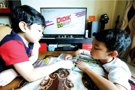  ?? -Bernama photo ?? Muhammad Afif Darwish Mohd Rashdan and his elder brother Muhammad Alif Daniel Mohd Rashdan, watching DidikTV@NTV7 while studying at their home in Putrajaya.