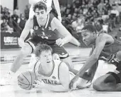  ?? ELI LUCERO AP ?? Utah State’s Max Shulga grabs the ball as San Jose State’s Alvaro Cardenas and Omari Moore defend.