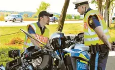  ??  ?? Hier bespricht sich der Einsatzlei­ter der Kontrollst­elle Ost, Florian Schöfl (rechts) mit Christian Stark von der Motorrad-Kontrollgr­uppe der Verkehrspo­lizei Kempten.