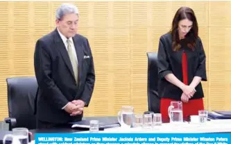  ?? —AFP ?? WELLINGTON: New Zealand Prime Minister Jacinda Ardern and Deputy Prime Minister Winston Peters stand with cabinet ministers as they observe a minute’s silence in respect for victims of the Dec 9 White Island volcanic eruption in parliament yesterday.