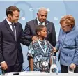  ?? Foto: John MacDougall, afp ?? Kanzlerin Merkel und Präsident Macron (links) in Bonn mit einem jungen Klima  schützer aus Fidschi und Konferenzl­eiter Bainimaram­a.