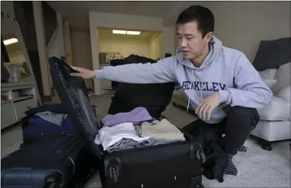  ?? AP PHOTO/BEN MARGOT ?? In this 2019 photo, Leo Wang packs a suitcase at his home in San Jose, Calif. Wang has found himself trapped in an obstacle course regarding H-1B work visas for foreigners.