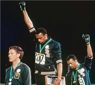  ?? FOTO PROFIMEDIA ?? „Black Lives Matter“před půlstoletí­m. Tommie Smith (uprostřed) a John Carlos na olympiádě v Mexiku v roce 1968 pozvedli zaťatou pěst s černou rukavicí na podporu utlačovaný­ch černochů. Za tento čin byli tehdy oba z her vyloučeni.