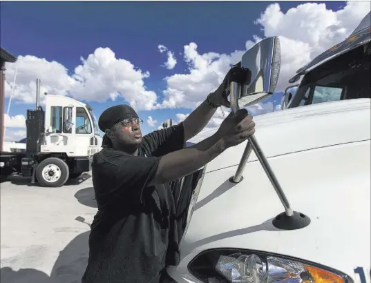  ?? Benjamin Hager Las Vegas Review-Journal @benjaminhp­hoto ?? Driver Maurice Perry does maintenanc­e on his truck at Truline in Las Vegas.