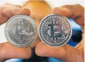  ?? Picture: AFP/ JACK GUEZ ?? ROLLERCOAS­TER CURRENCY A person holding a visual representa­tion of the digital crypto-currency Bitcoin, at the ‘Bitcoin Change’ shop in the Israeli city of Tel Aviv