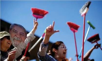  ?? Photograph: Adriano Machado/Reuters ?? Demonstrat­ors raise their brooms as they sweep outside the justice ministry headquarte­rs during a protest against Moro earlier this month.