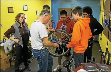  ?? PHOTO BY EMILY FLYNN ?? ‘Midtown Mechanics’ students (counterclo­ckwise from front right) Trent Frazer, Milo Witte, Alex Rodriguez and Brenden Fuoco (partially hidden) watch profession­al bike mechanic and lead instructor Anthony Ferrante, center, work on a wheel. Assistant...