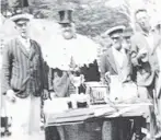  ??  ?? Prizegivin­g of trophies and silver cups. ‘‘Commodore’’ Herb Lanham (left) stands next to the selfstyled ‘‘Mayor of Hoopers Inlet’’, Jim Walquist, and unknown others.