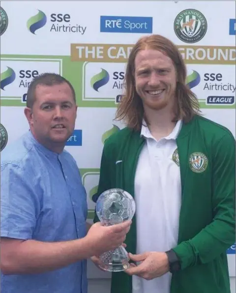  ??  ?? Bray Wanderers player of the month for June, Hugh Douglas, receiving his award from Mick Brady on behalf of sponsors Fitzpatric­k Motors, Bray.