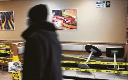  ?? Spencer Platt / Getty Images ?? Emergency tape blocks off seating Friday at a fast-food restaurant in Brooklyn, N.Y. Restaurant­s, bars, hotels, casinos, movie theaters and other entertainm­ent venues shed nearly 500,000 jobs last month, the most since April.