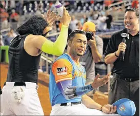  ?? CARL JUSTE / MIAMI HERALD ?? Stanton, getting the whipped-cream treatment after his 50th, has tried to stay diplomatic during the debate — especially since Barry Bonds is his former coach.