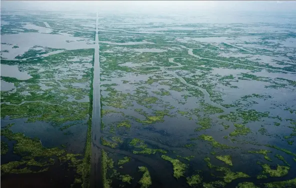  ?? BONNIE JO MOUNT/WASHINGTON POST ?? A gas transmissi­on pipeline cuts through the landscape in St. Bernard Parish, La. Pipelines run from the Gulf to refineries in coastal Louisiana.