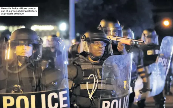  ??  ?? Memphis Police officers point a gun at a group of demonstrat­ors as protests continue