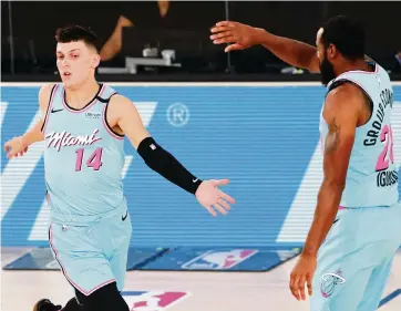  ?? POOL Getty Images ?? Tyler Herro, left, is among several Heat players experienci­ng the playoffs for the first time who can look for guidance to Andre Iguodala, right, who has three NBA championsh­ips on his resume.