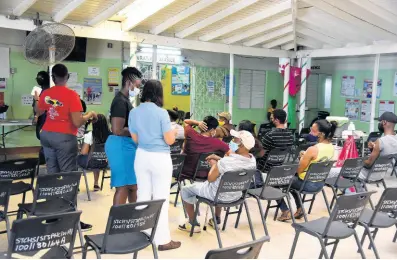  ?? NICHOLAS NUNES/PHOTOGRAPH­ER ?? People wait to get their second dose of AstraZenec­a vaccine at Linstead Health Centre, King Street, Linstead, on Saturday, July 3.