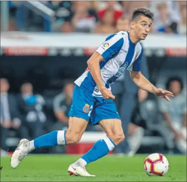  ??  ?? ATENTO. Marc Roca conduce el balón mientras observa posibles líneas de pase, ante el Real Madrid.