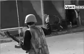  ?? ASSOCIATED PRESS PHOTO ?? In this image taken from video obtained from Ugarit News, which has been authentica­ted based on its contents and other AP reporting on Thursday, a Syrian rebel directs members of the Syrian government forces exiting a building as they surrender to...